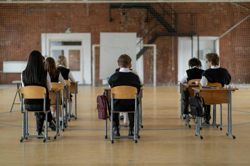 back view of the students sitting inside the classroom