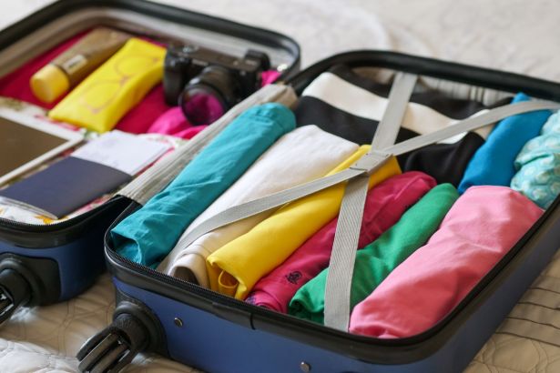 blue luggage with folded clothes