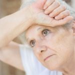 elderly woman leaning on a glass