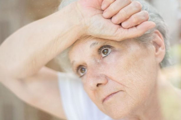 elderly woman leaning on a glass