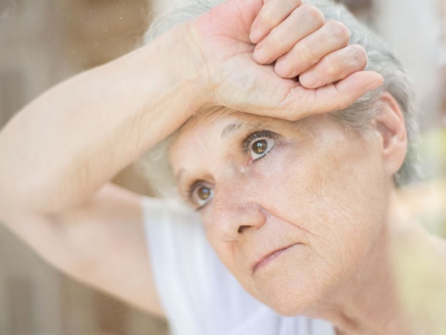 elderly woman leaning on a glass