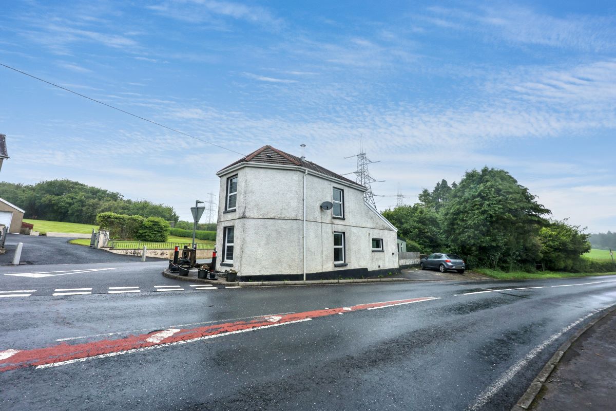 Gate House in Llannon standing at the junction with roads passing on both sides