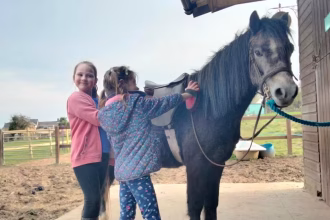 Two young girl's with a horse at Brynteg Farm and Wellbeing Sanctuary