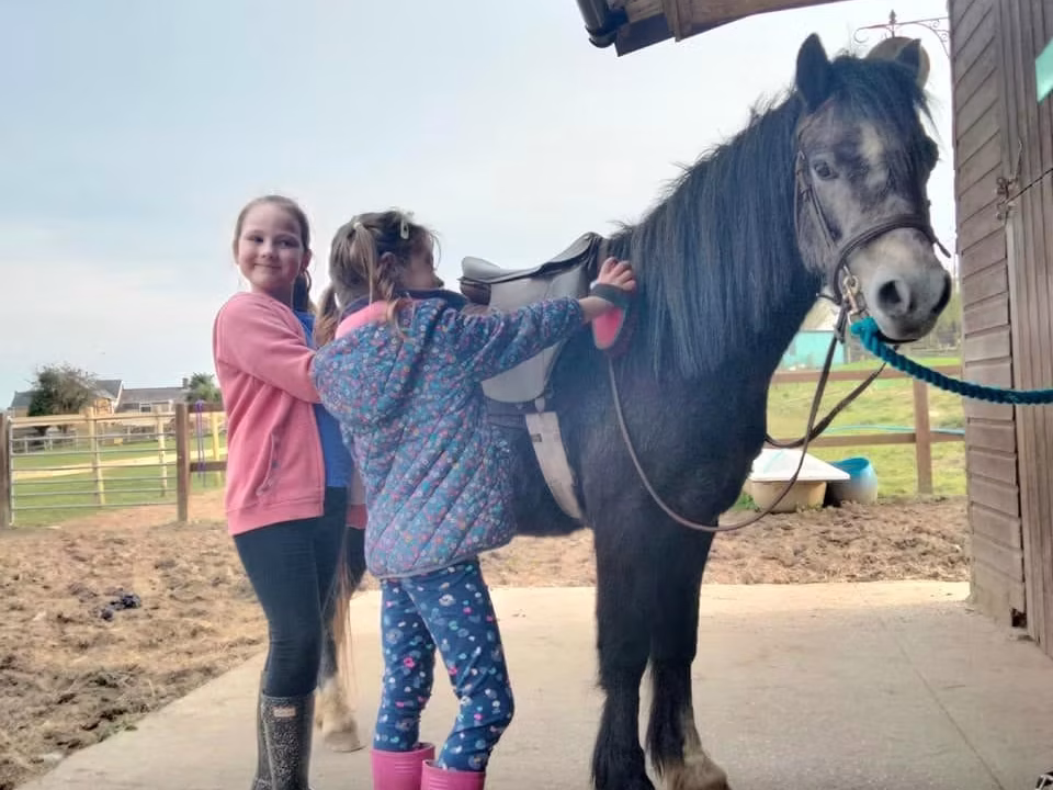 Two young girl's with a horse at Brynteg Farm and Wellbeing Sanctuary