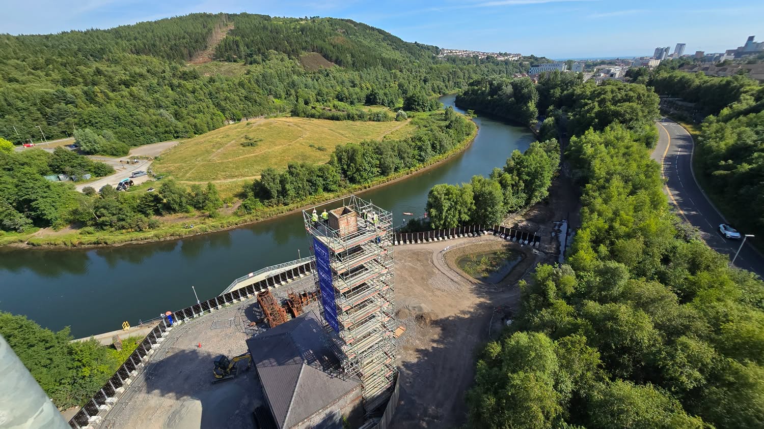 Aerial view from the top of the scaffolded copperworks chimney, with the River Tawe, woodland and Swansea in the distance