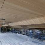 The new angled oak-panelled ceiling installed above the balcony level of the Princess Royal Theatre auditorium, with scaffolding on the construction site below