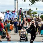 Crowds walking along Oystermouth Road past food stalls and marquees during a previous Wales Airshow