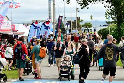 Crowds walking along Oystermouth Road past food stalls and marquees during a previous Wales Airshow
