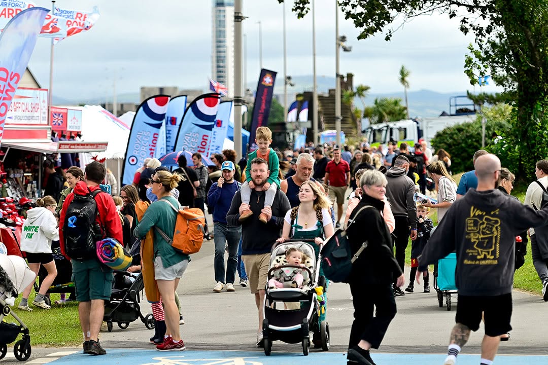 Crowds walking along Oystermouth Road past food stalls and marquees during a previous Wales Airshow