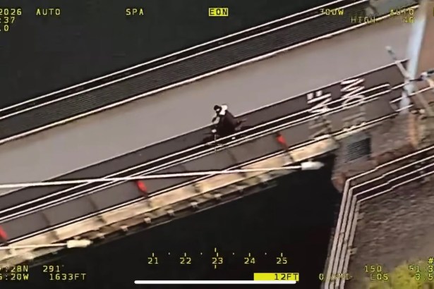 Aerial police camera view of a rider on an electric motorbike crossing a pedestrian footbridge over water