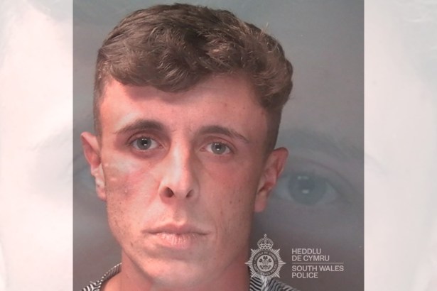 Custody photo of Flynn Johnson-Andrews, a man with short dark hair, issued by South Wales Police