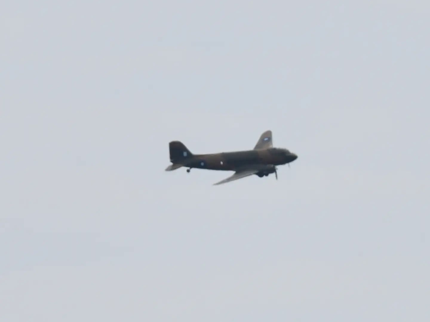 The Battle of Britain Memorial Flight Dakota in wartime camouflage flying over Swansea Bay