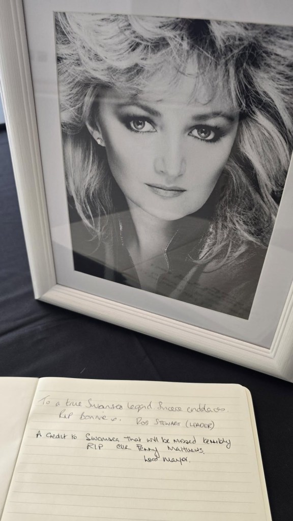 Handwritten tributes in the Bonnie Tyler book of condolence beside a framed black and white portrait of the singer