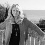 Bonnie Tyler standing on a balcony overlooking the sea, in a black and white photograph