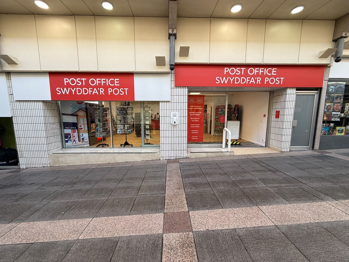 The temporary Bridgend Post Office unit with two red bilingual Post Office signs and a services banner in the window