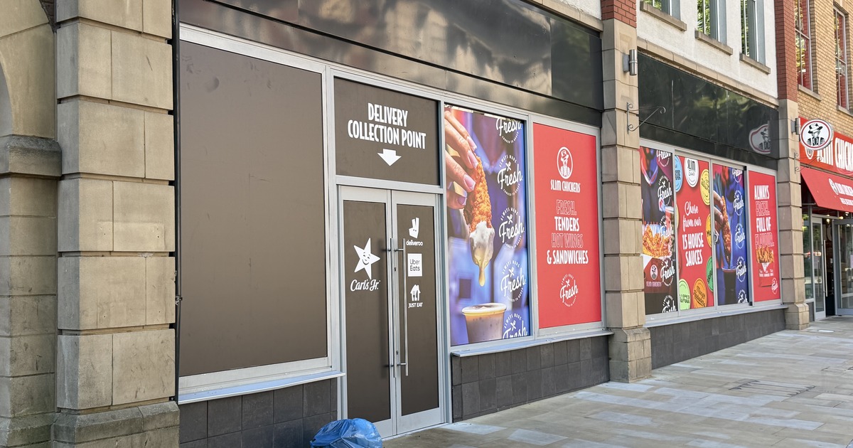 The former Carl's Jr entrance on Wind Street, now marked Delivery Collection Point, with the Carl's Jr star and Deliveroo, Uber Eats and Just Eat logos on the doors