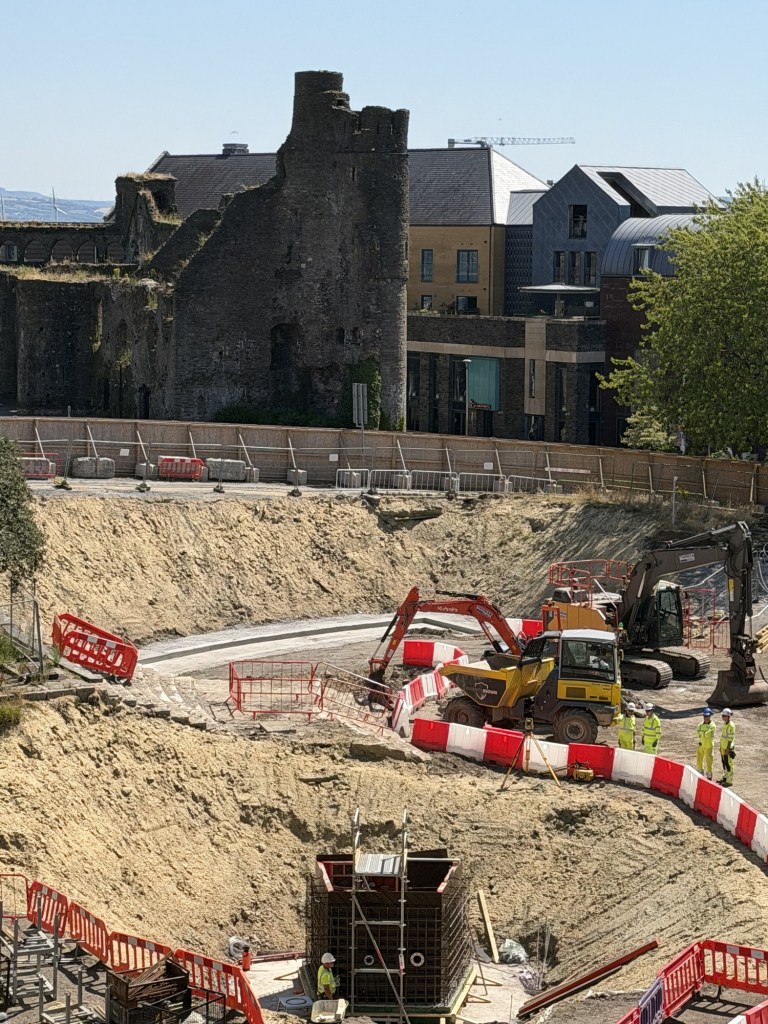 The excavated Castle Square site with diggers at work below the ruins of Swansea Castle