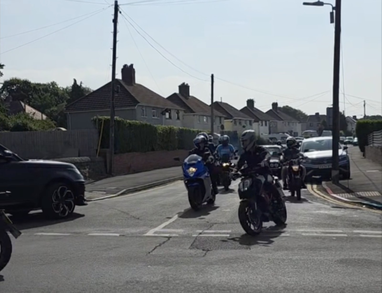 A line of motorbikes riding along a residential street during the ride-out