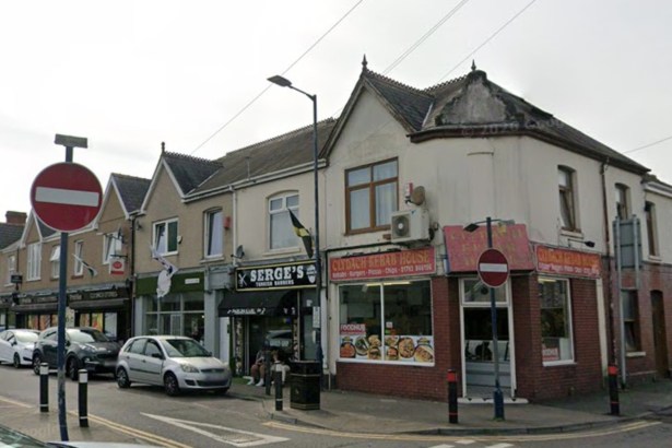 A corner parade of shops on High Street in Clydach including Clydach Kebab House and Serge's Turkish barbers with cars parked outside