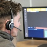 A call handler wearing a headset looking at a screen in the Dyfed-Powys Police Force Communication Centre