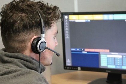 A call handler wearing a headset looking at a screen in the Dyfed-Powys Police Force Communication Centre
