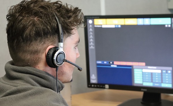A call handler wearing a headset looking at a screen in the Dyfed-Powys Police Force Communication Centre