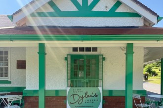 The green and white pavilion in Cwmdonkin Park with the Dylan's Coffee Shop sign at its entrance