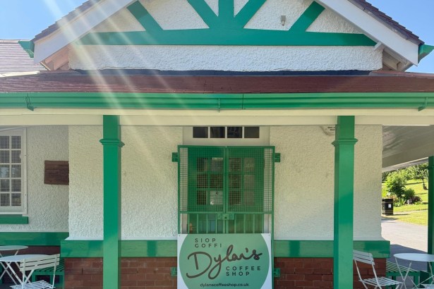 The green and white pavilion in Cwmdonkin Park with the Dylan's Coffee Shop sign at its entrance