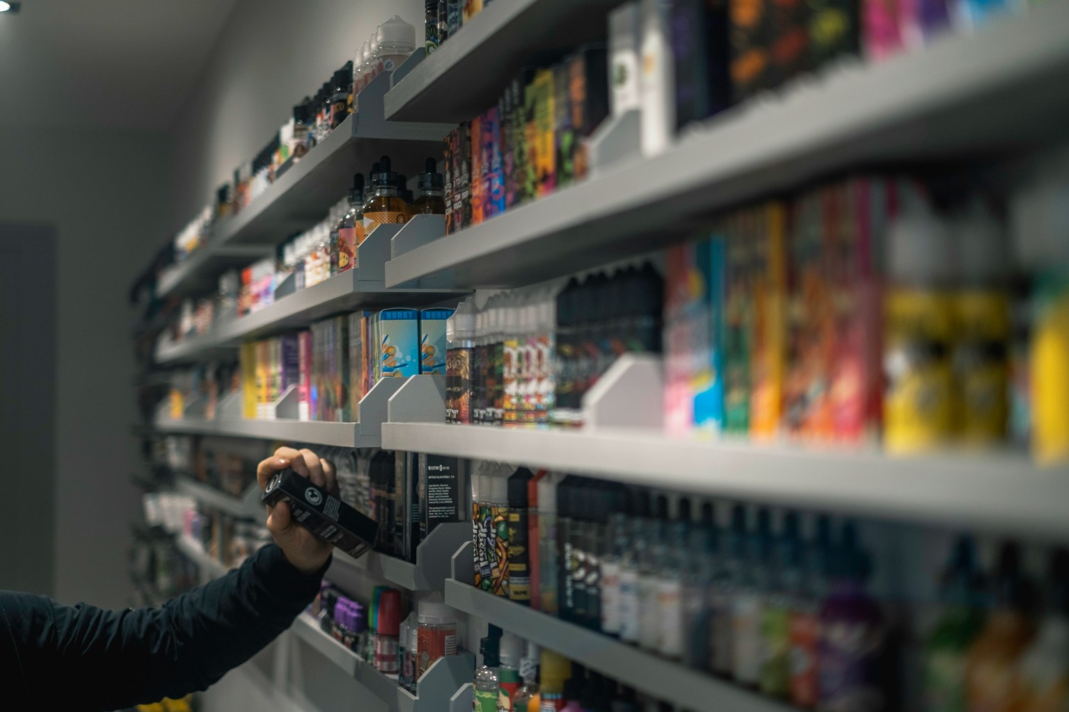 Rows of brightly coloured disposable vapes in assorted flavours lined up on display
