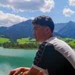 Swansea City signing Elijah Just looking out over a lake with mountains in the background