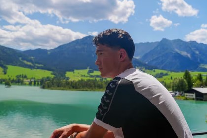 Swansea City signing Elijah Just looking out over a lake with mountains in the background