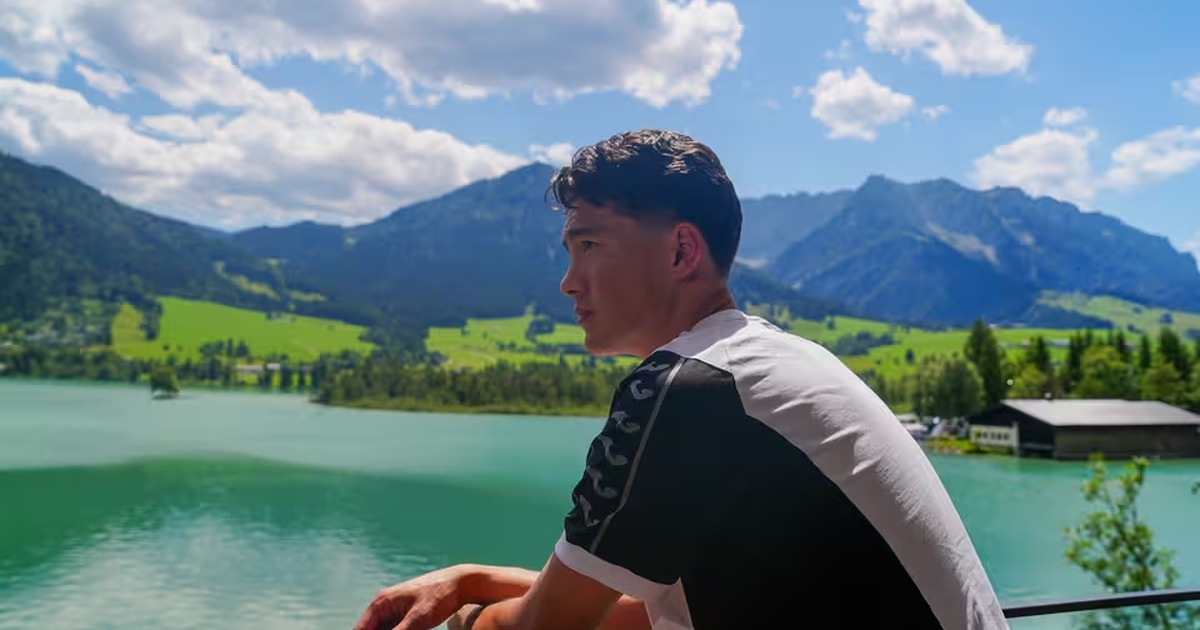 Swansea City signing Elijah Just looking out over a lake with mountains in the background