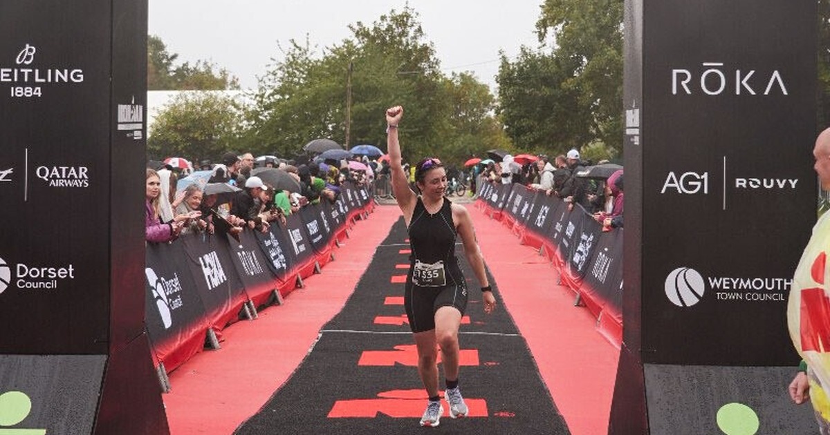 Emily Bond raising her fist as she crosses the IRONMAN 70.3 Weymouth finish line