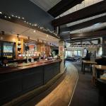 Interior dining area of the Bagle Brook with exposed wooden beams, booth seating and tables laid for service