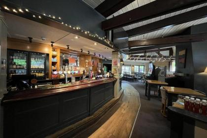 Interior dining area of the Bagle Brook with exposed wooden beams, booth seating and tables laid for service
