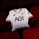 The new Swansea City 2026-27 home shirt laid out on a red seat in the Grand Theatre