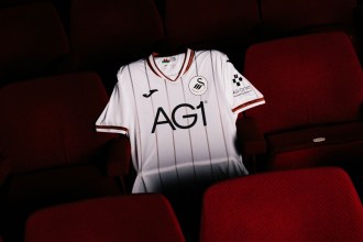 The new Swansea City 2026-27 home shirt laid out on a red seat in the Grand Theatre
