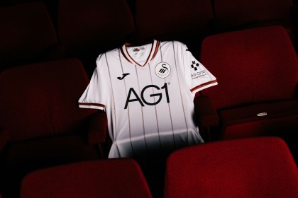 The new Swansea City 2026-27 home shirt laid out on a red seat in the Grand Theatre
