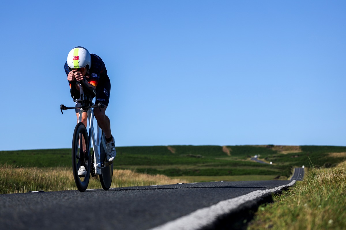 Nikki Bartlett in blue Erdinger kit rides in an aero tuck on a time trial bike