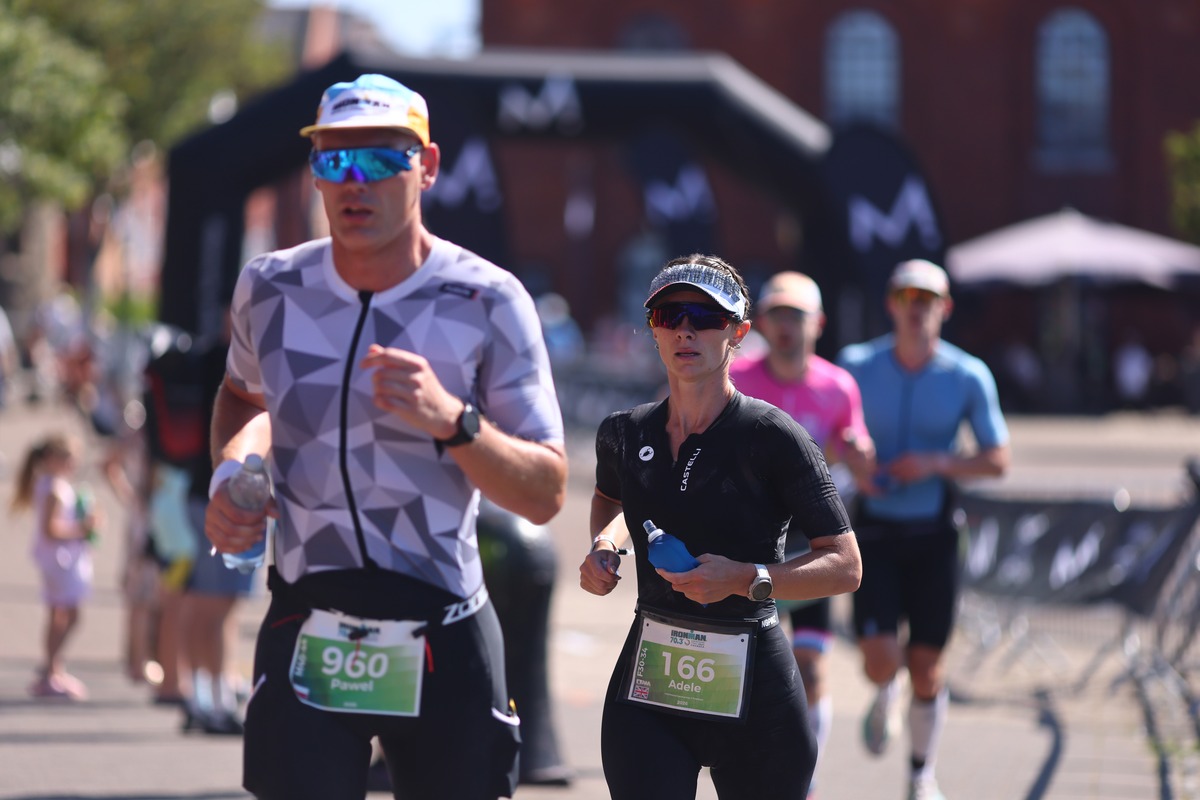 A runner in Team NFT kit passes crowds outside the National Waterfront Museum