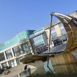 The Leaf Boat, a large curved glass and steel sculpture shaped like a leaf, beside the water feature in Swansea's Castle Square