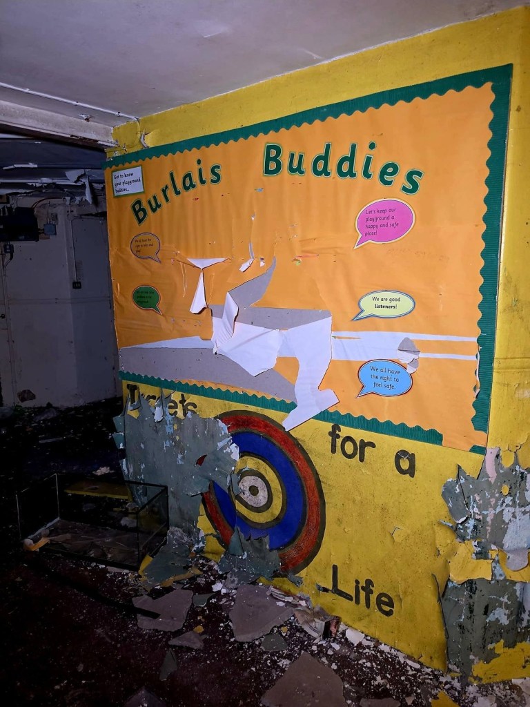 Burlais Buddies yellow playground display board with speech bubbles, peeling from a wall in the dark