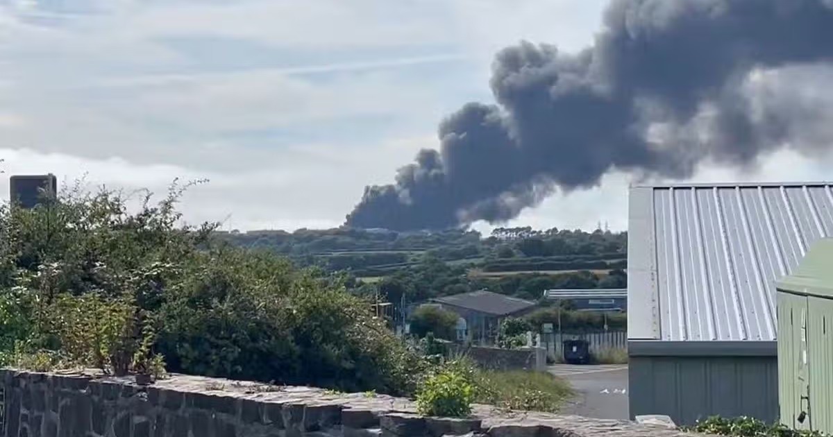 A large plume of black smoke rises over rooftops and countryside near Milford Haven following a fire at the Impala terminal.
