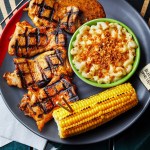 A plate of flame-grilled peri-peri chicken with macaroni cheese and corn on the cob at Nando's