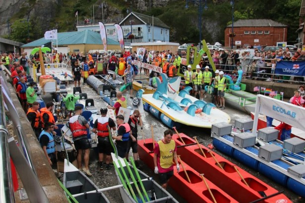 Colourful homemade rafts and crews in fancy dress at the Knab Rock slipway, with crowds watching behind