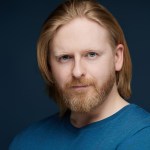 Actor Richard Goss, from Swansea, in a blue t-shirt against a dark background