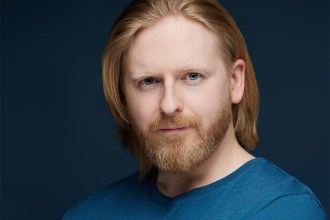 Actor Richard Goss, from Swansea, in a blue t-shirt against a dark background