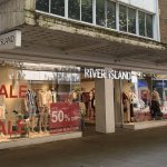 River Island's Oxford Street store in Swansea with red sale signs in the windows and Popeyes next door