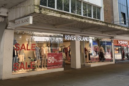River Island's Oxford Street store in Swansea with red sale signs in the windows and Popeyes next door