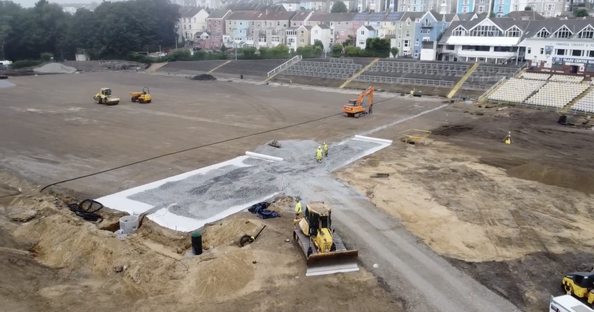 Aerial view of St Helen's with the pitch stripped to bare earth, drainage stone laid in a cross, and empty terracing behind